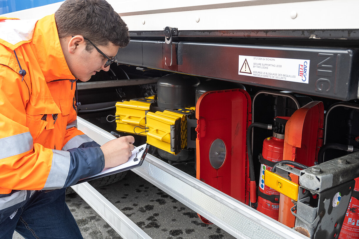 Kauf­frau/-mann für Spe­di­ti­on und Lo­gis­tik­dienst­leis­tun­gen am kontrollieren der Ausstattung eines LKWs