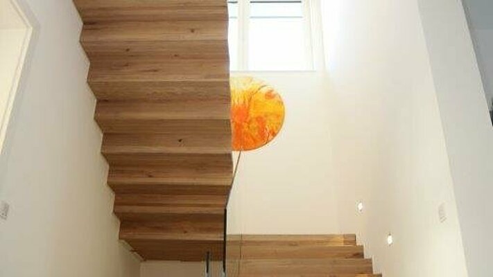 Treppe mit Geländer aus Glaswänden und Holzstufen von BECK Treppen
