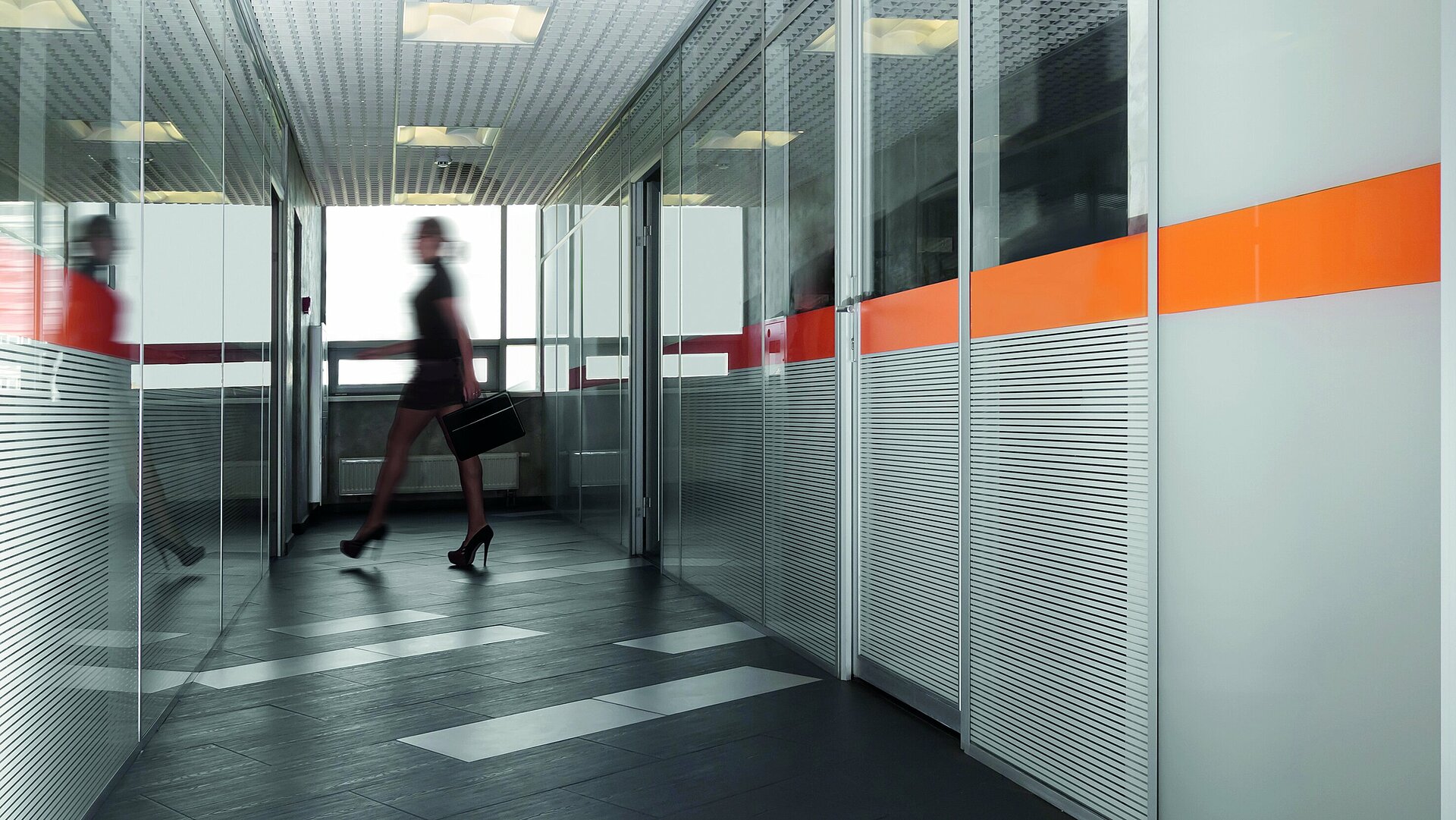 Büroflur mit Büroräumen aus Glaswänden und orangenem Glaslack Akzenten
